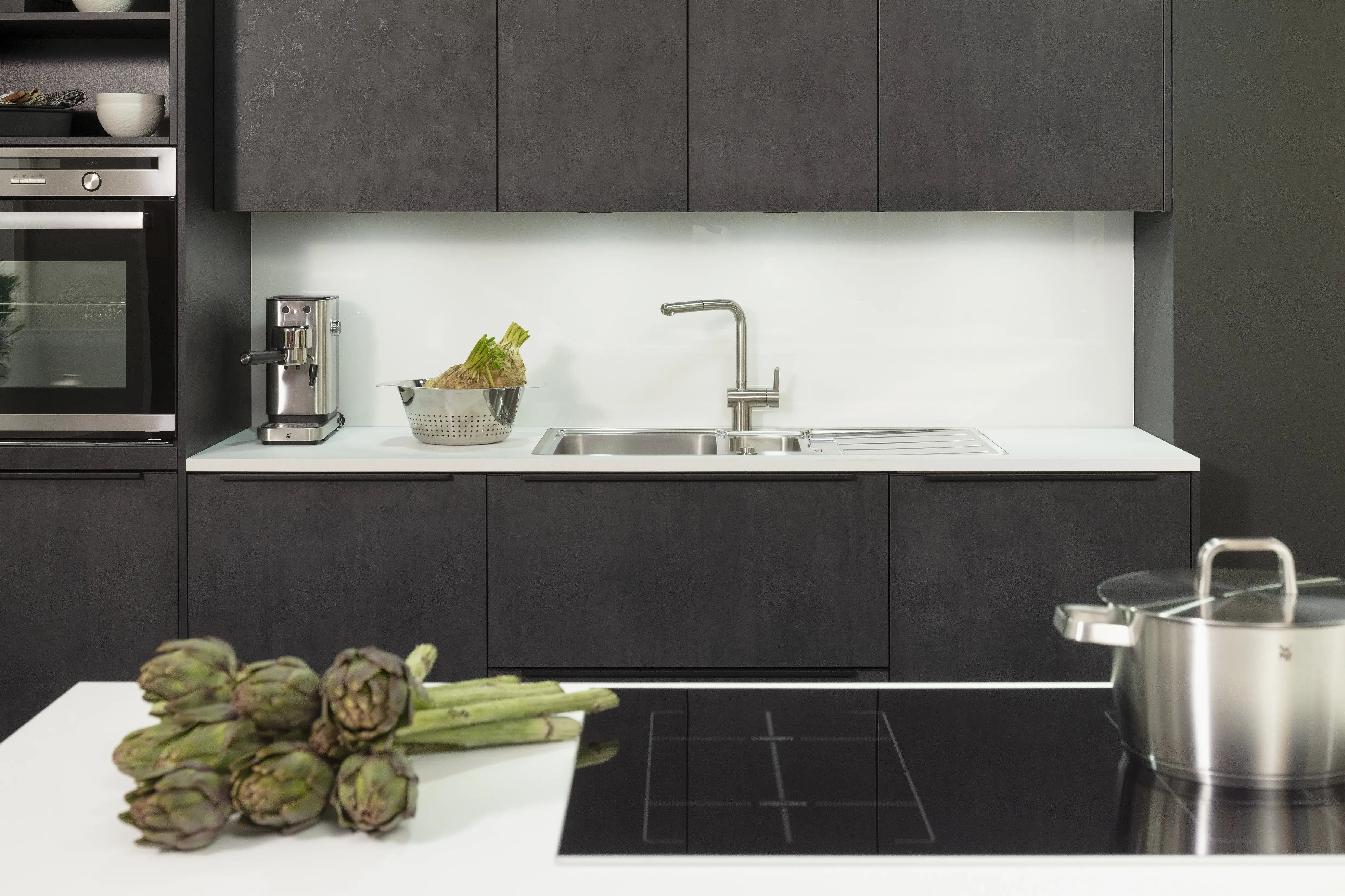 Concept130 Front: Comet Spachtelbeton schwarz Kunststoff strukturiert Murano Bril Kristallweiss Designglas eingefasst APL: Kristallweiß Perfect Sense 25 mm Geräte Blaupunkt Spüle und Armatur: Franke  Features: Dachschräge, Maßeinbau, Sideboard, offene Regale mit Downlights.