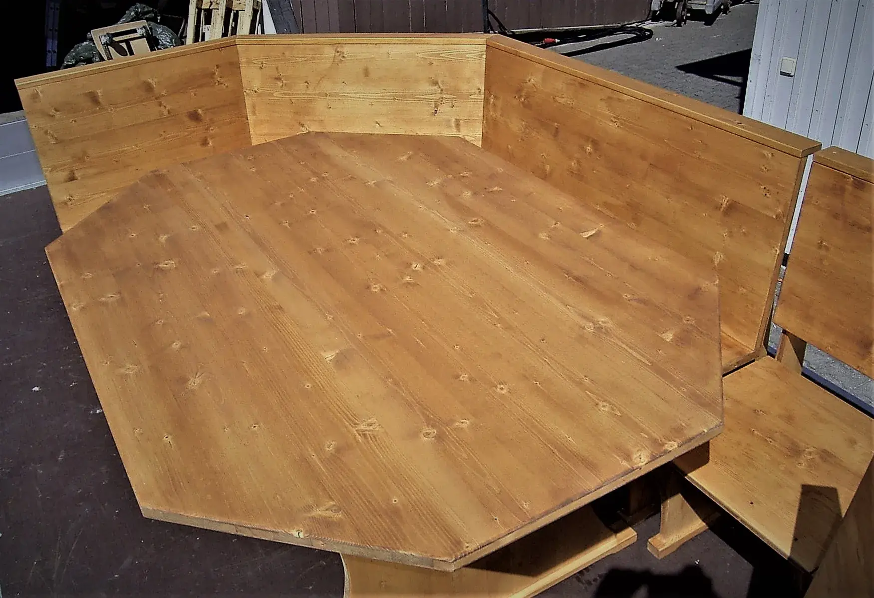 Eckbank aus Holz mit achteckigem Tisch und hoher Rückenlehne