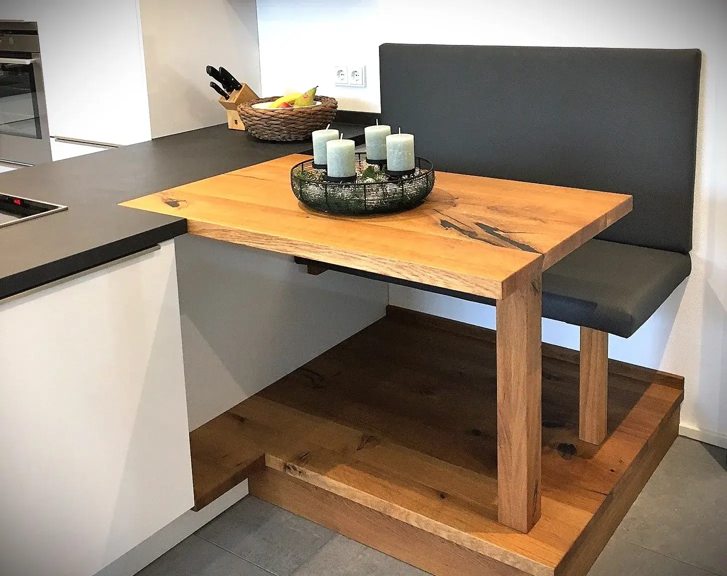 Moderne Holzecke mit Bank, Esstisch und Kerzenkranz in einer Küche.