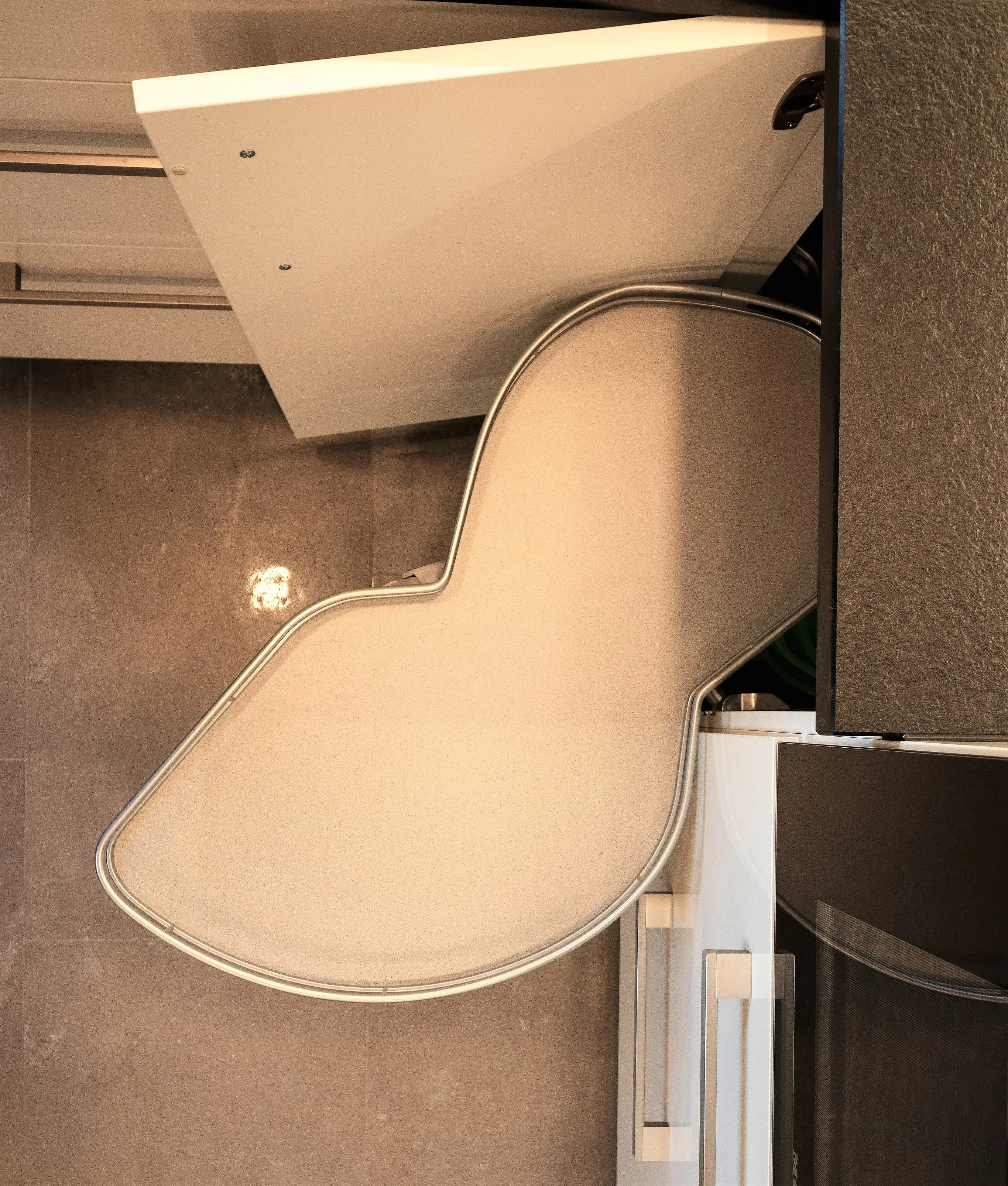 Ausziehbares L-förmiges Küchenregal mit geöffneter Schranktür.